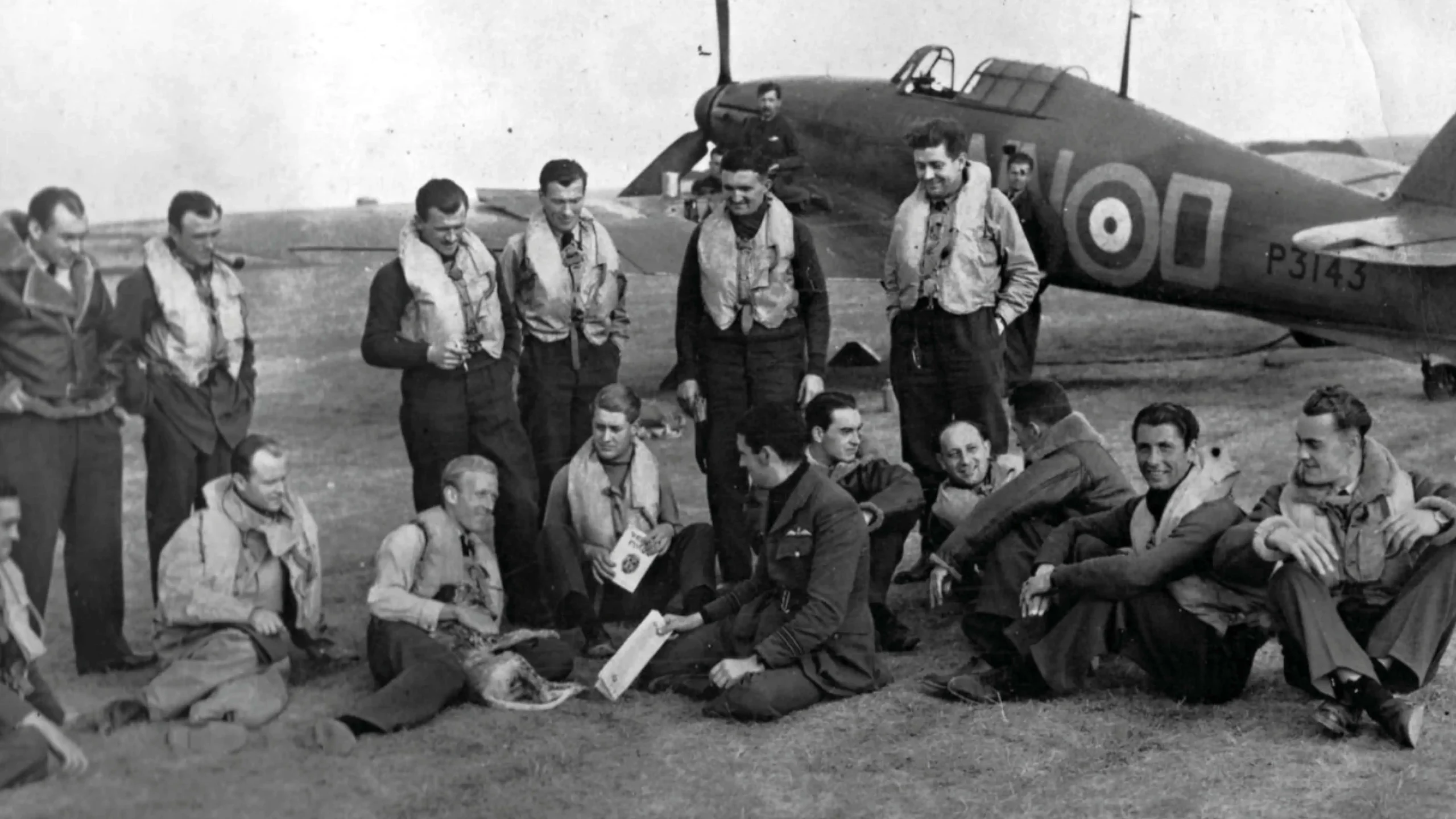 Group of RAF pilots resting near Hawker Hurricane Mk I aircraft P3143 WN‑O during World War II