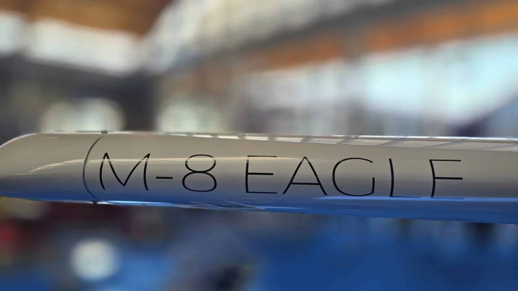 M‑8 Eagle wing detail Wingtip of Orlican M‑8 Eagle aircraft with printed model name on glossy composite surface inside hangar